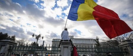 Участник протеста, организованного партией AUR, размахивает румынским флагом перед парламентом в Бухаресте, январь 2024, Getty images ipg-journal.io