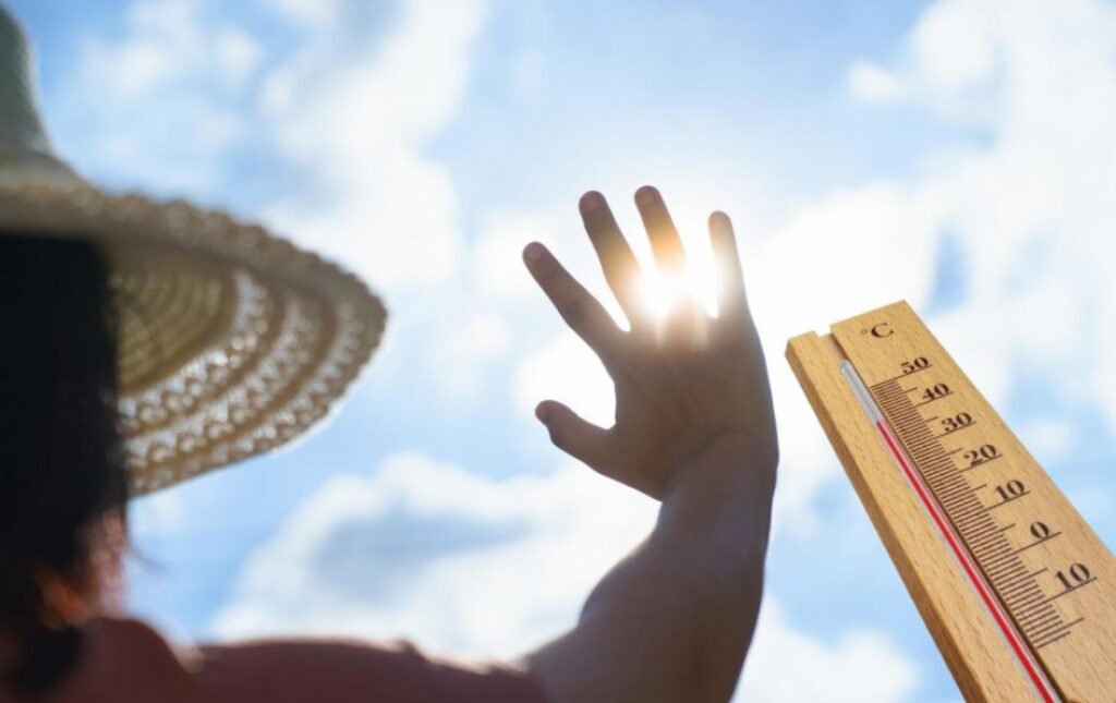 Человек закрывает лицо от солнца на фоне термометра с температурой 40°C