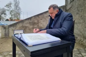Милорад Додик подписывает документ на открытом воздухе