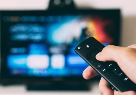 Пульт дистанционного управления на фоне экрана Smart TV