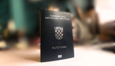 Хорватский паспорт на фоне размытого интерьера, фото 2025 года