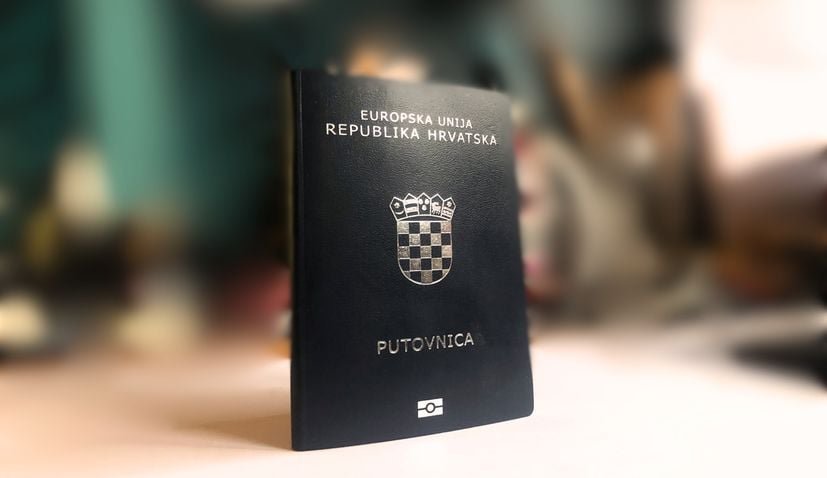 Хорватский паспорт на фоне размытого интерьера, фото 2025 года