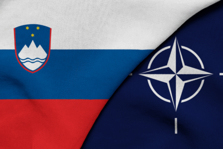 Флаг Словении и эмблема НАТО на фоне обсуждения оборонных расходов