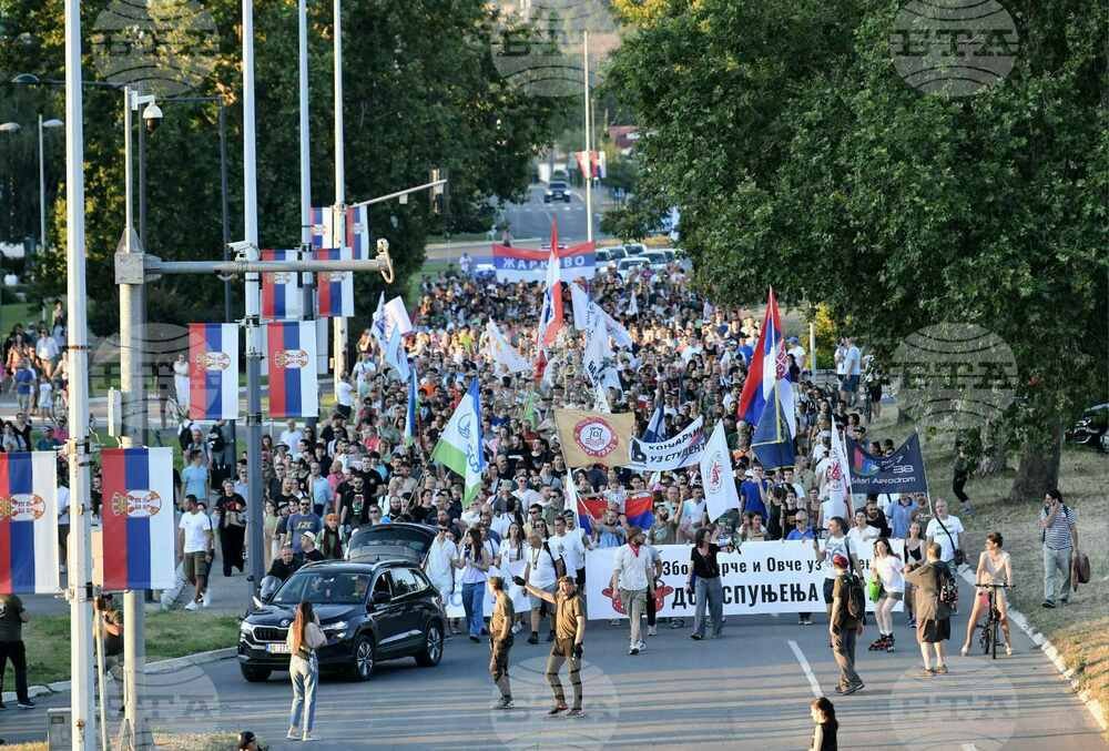 Марш протестующих с флагами и транспарантами на мосту Газела в Белграде, июль 2025