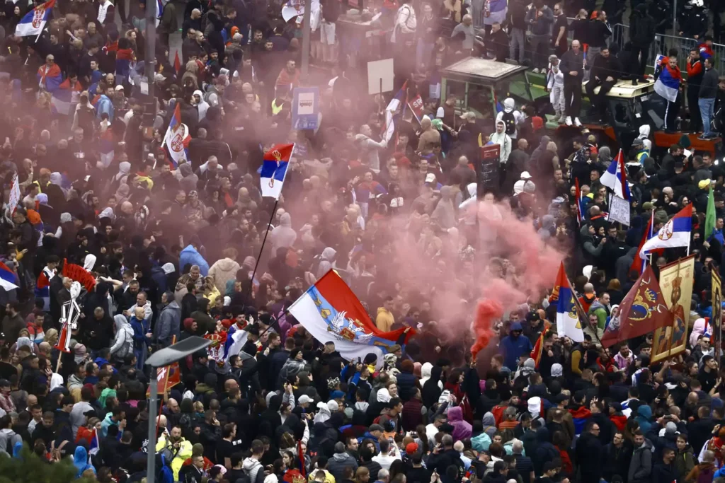 Протест в Белграде 15 марта 2025 года с сербскими флагами и дымом