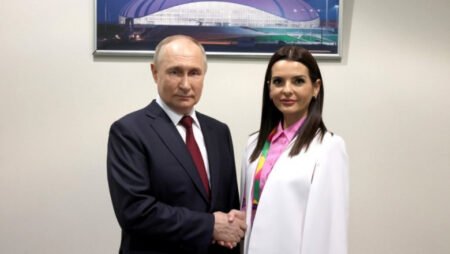 Владимир Путин и Евгения Гуцул пожимают руки на фоне фотографии спортивного комплекса