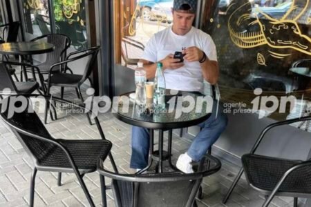 Константин Цуцу в кафе на террасе в Тирасполе, сидит за столом с телефоном