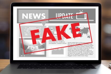 Изображение с надписью FAKE на экране ноутбука, символизирующее фейковые новости