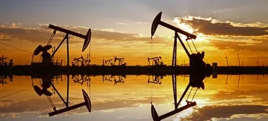 Нефтяные качалки на фоне заката — добыча нефти