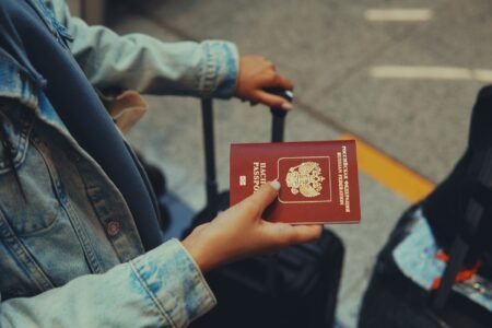 Российский загранпаспорт в руке путешественника в аэропорту