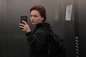 Молодая женщина делает селфи в зеркале лифта