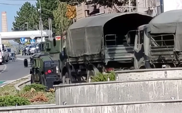 Военные грузовики и бронетехника на улице в Косово