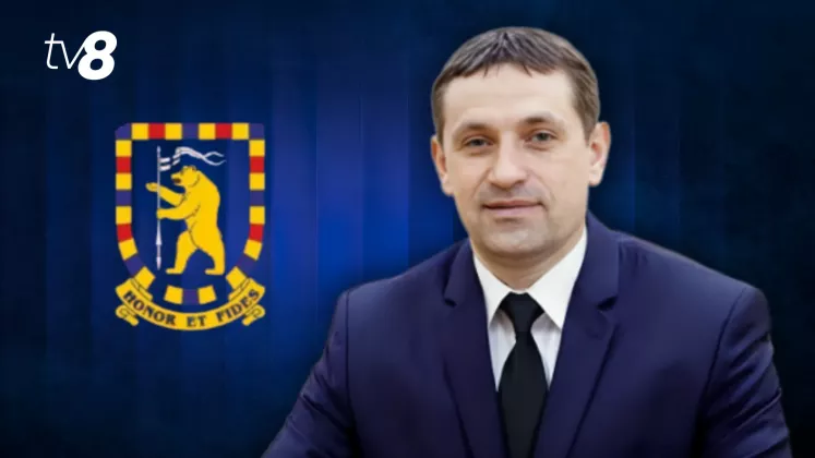 Василе Попа на фоне герба SPPS Республики Молдова