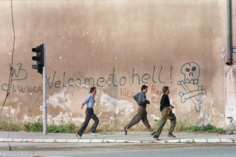 Люди бегут по улице Сараево во время обстрела снайперов в 1993 году