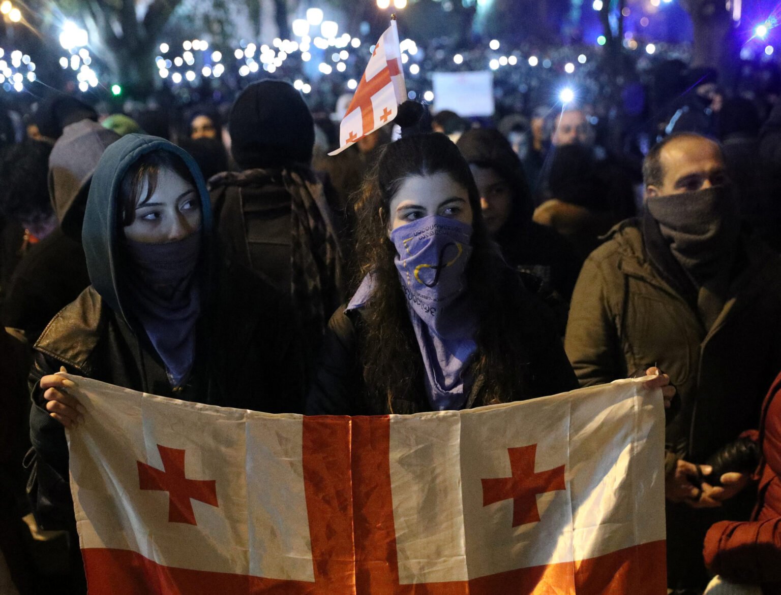 Молодые женщины с грузинским флагом на ночном протесте в Тбилиси