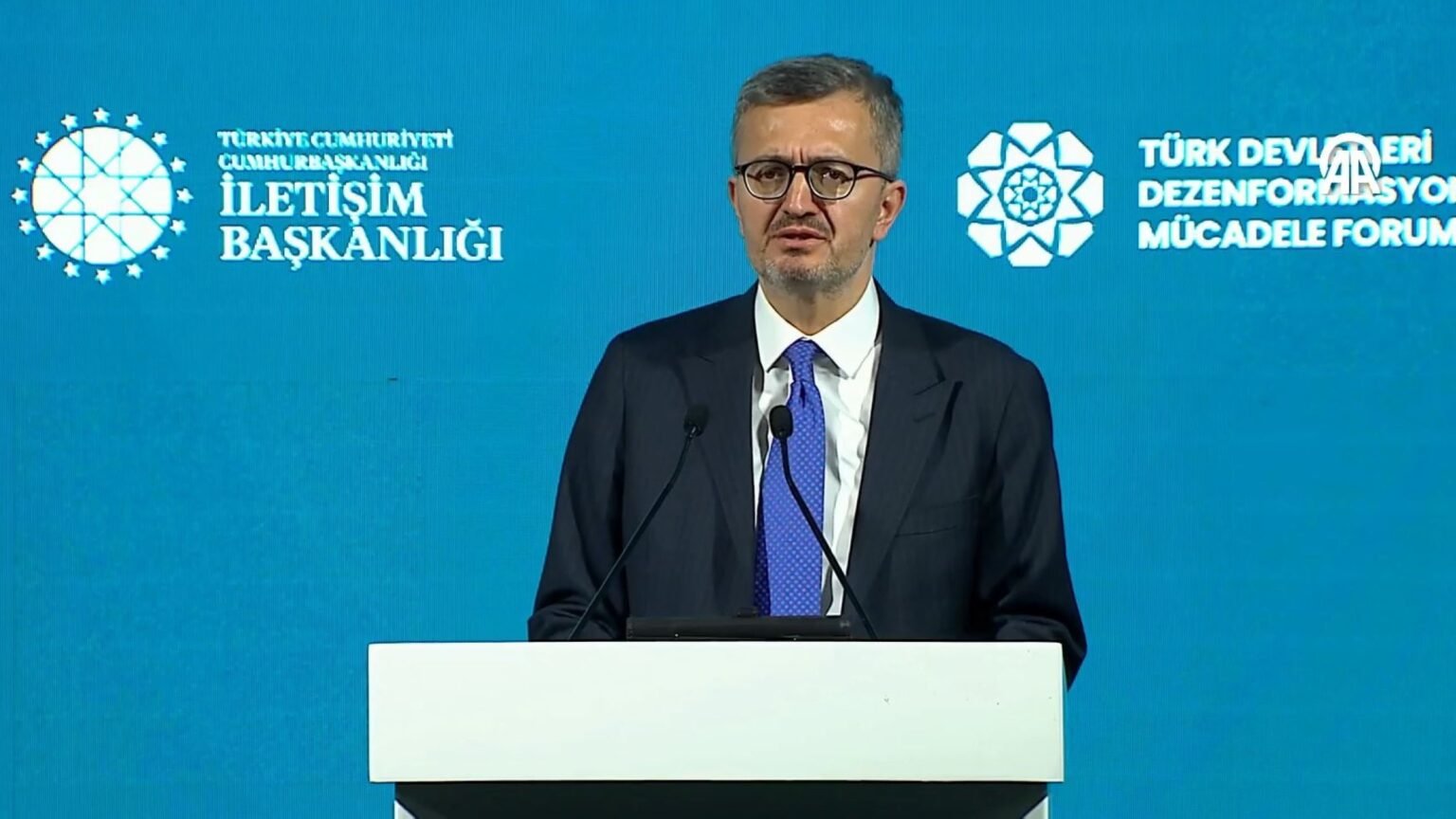 Глава Дирекции коммуникаций Турции Бурханеттин Дуран выступает на трибуне Форума тюркских государств по борьбе с дезинформацией на фоне логотипов организаторов