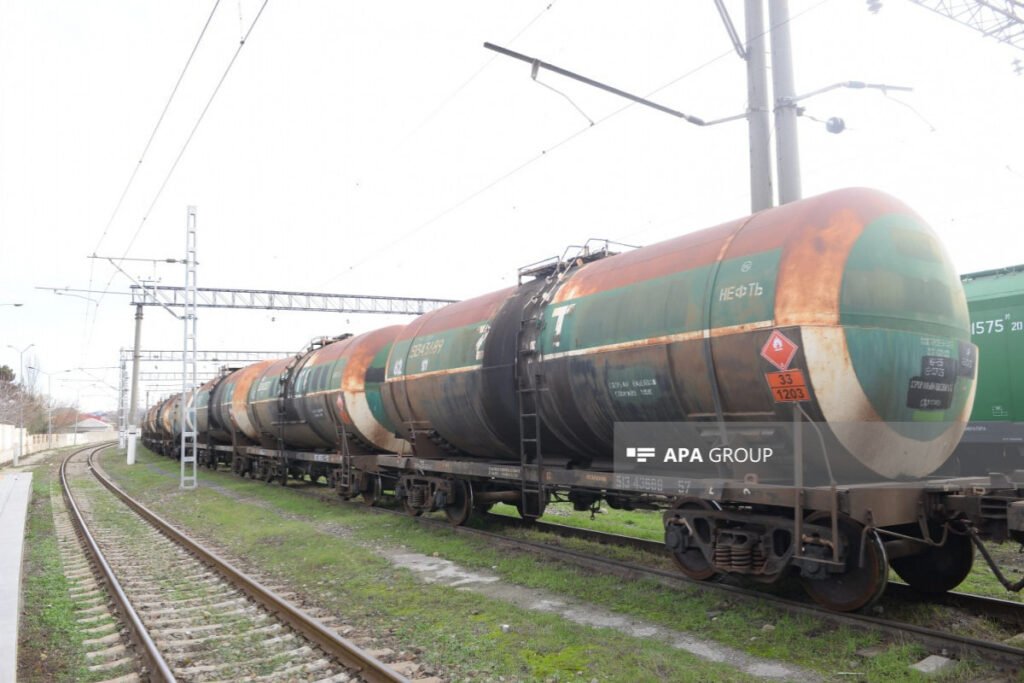 Железнодорожные вагоны-цистерны с надписью «НЕФТЬ» на путях, логотип APA Group
