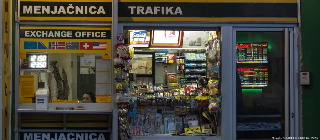 Обменный пункт (menjačnica) с табачным киоском в Сербии, жёлтая вывеска с курсами валют и флагами стран