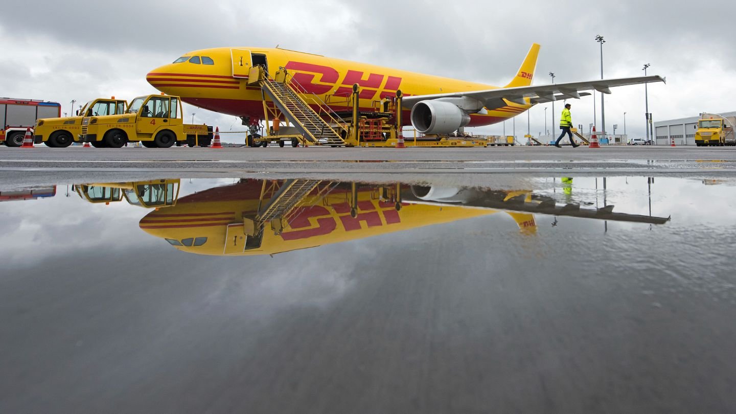 Грузовой самолёт DHL на лётном поле аэропорта Лейпциг с отражением в луже