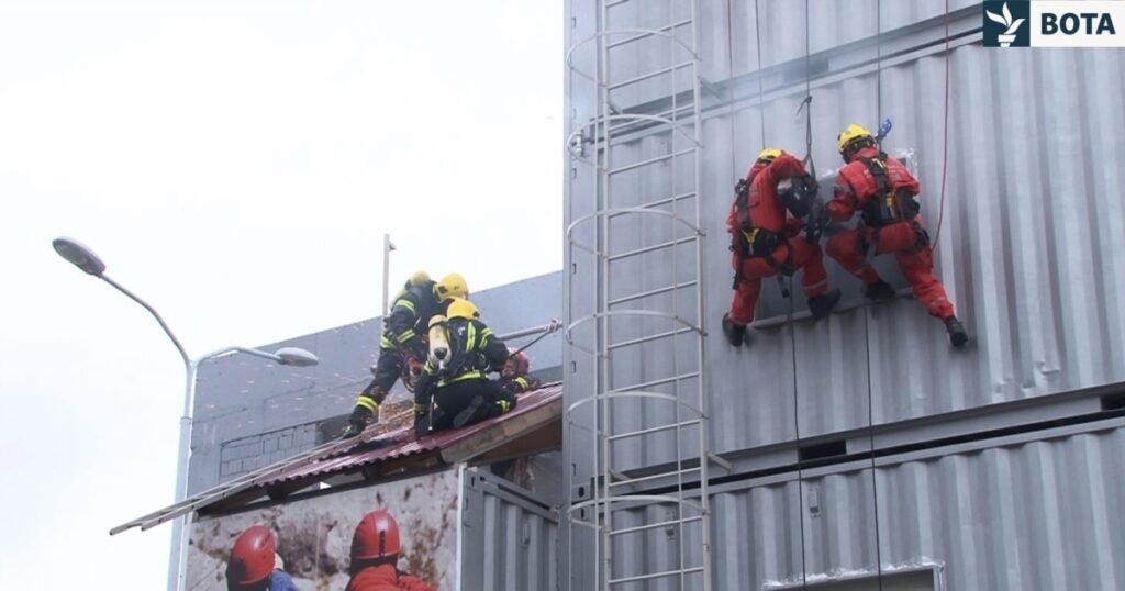 Спасатели в красной и жёлтой форме проводят учения на тренировочном комплексе РСГЦ в Нише