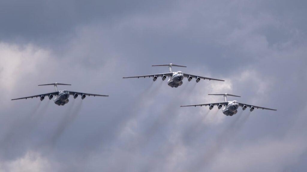 Три российских военно-транспортных самолёта Ил-76 в строю на фоне грозового неба