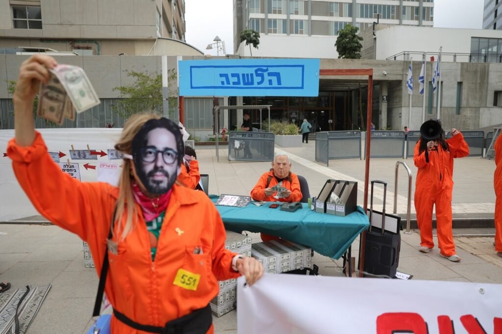 Участники антикоррупционного протеста в Израиле в оранжевых робах с масками Эйнхорна