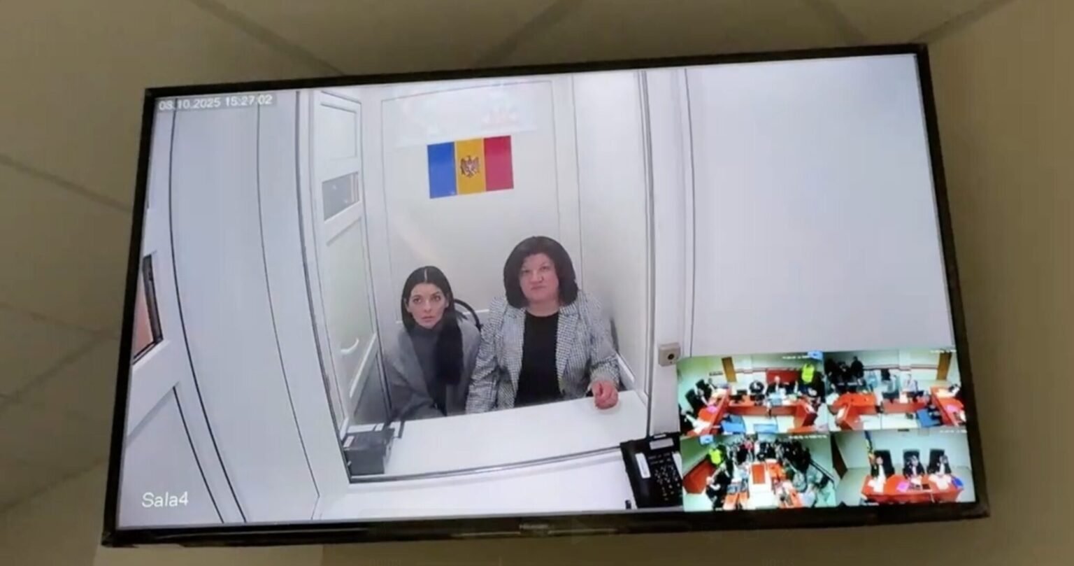 Евгения Гуцул и Светлана Попан участвуют в судебном заседании по видеосвязи из следственного изолятора. На экране видны обе обвиняемые на фоне флага Молдовы