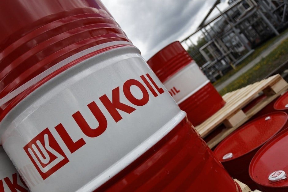 Нефтяные бочки с логотипом Лукойл на промышленном складе — иллюстрация к статье о санкциях США