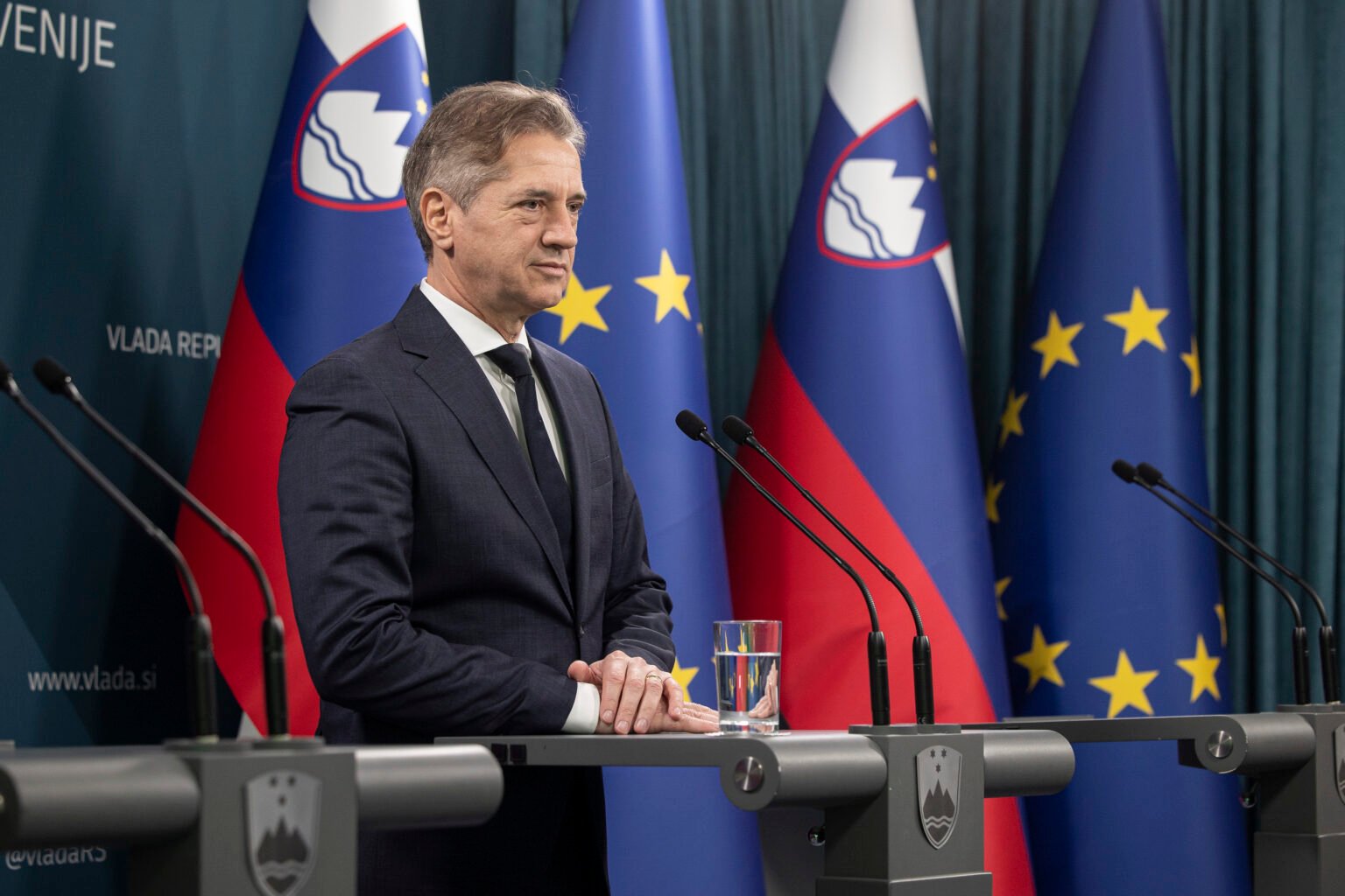 Премьер-министр Словении Роберт Голоб выступает на пресс-конференции на фоне флагов Словении и Европейского союза