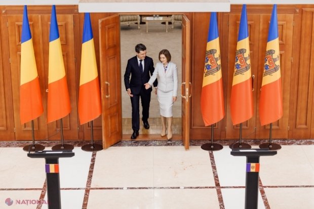 Президент Румынии Никушор Дан и президент Молдовы Майя Санду входят в зал переговоров на фоне государственных флагов обеих стран