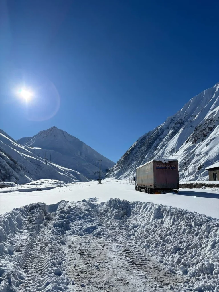 Грузовик на заснеженной Военно-Грузинской дороге в горах Кавказа