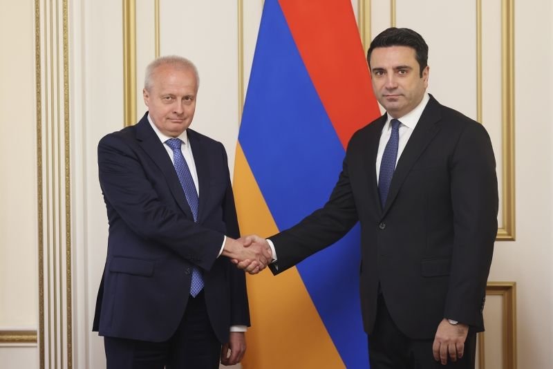 Посол России Сергей Копыркин и спикер парламента Армении Ален Симонян обмениваются рукопожатием на фоне армянского флага