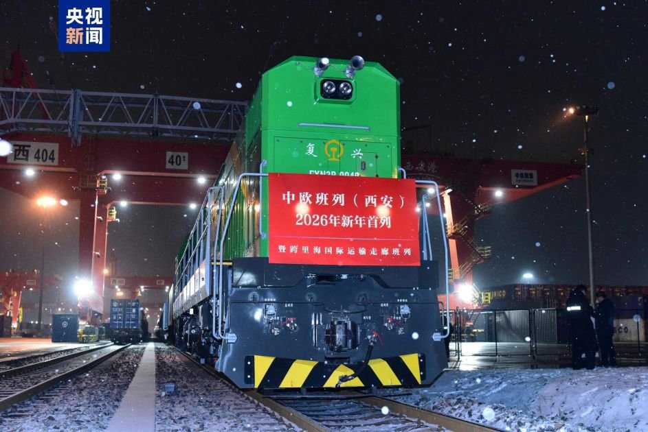 Зелёный локомотив China Railway Express с баннером «2026年新年首列» на контейнерном терминале в Сиане