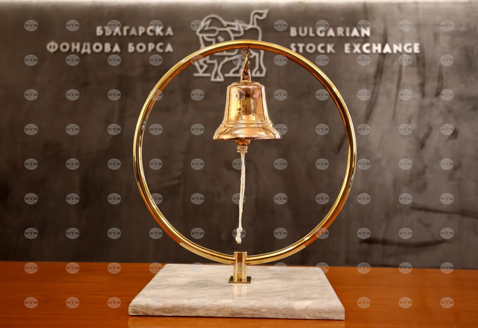 Биржевой колокол Болгарской фондовой биржи на фоне логотипа с быком