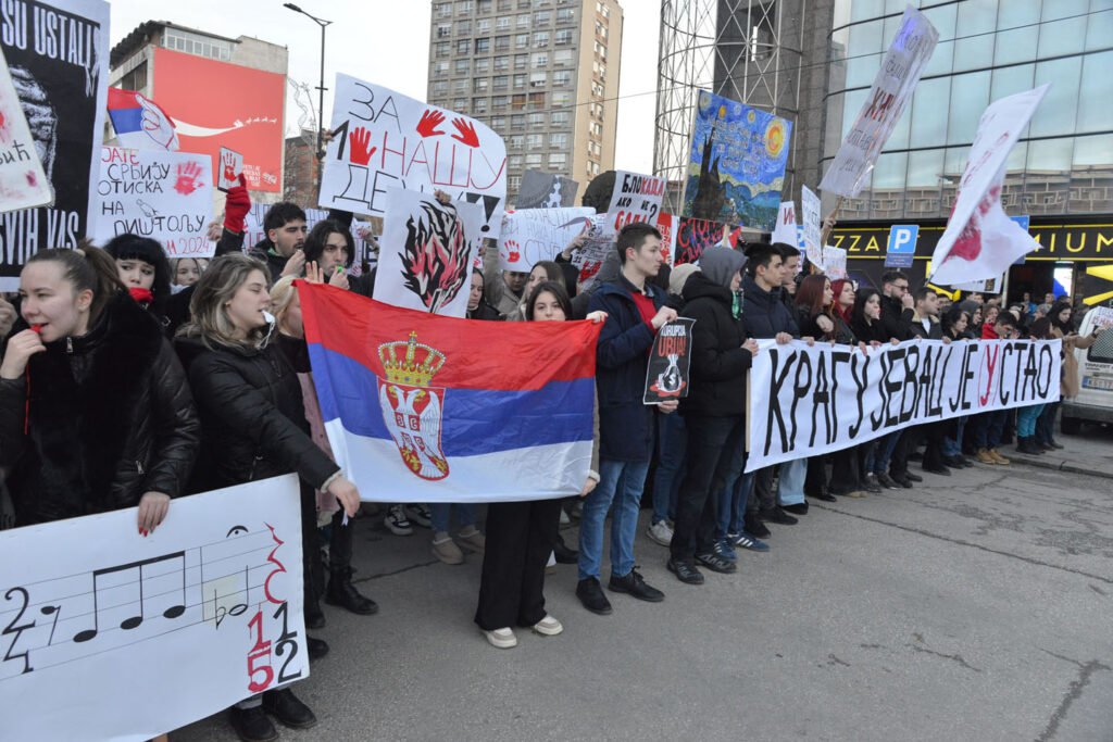 Студенты с сербскими флагами и транспарантами на протесте в Крагуевце — надпись «Крагуевац устал» и лозунги против коррупции. Фото: Vreme