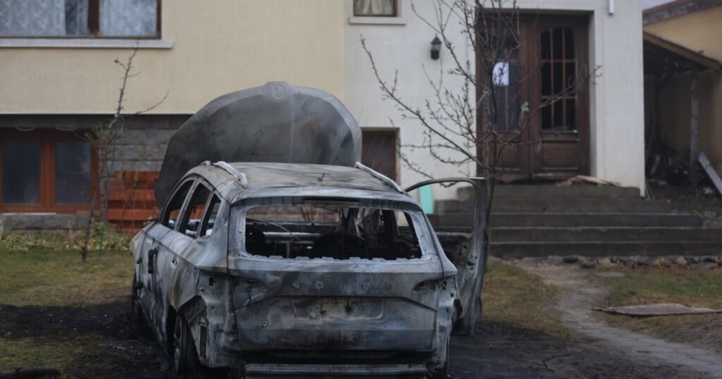 Мэры Болгарии выходят на протест после поджога дома коллеги Сгоревший автомобиль перед домом мэра в Бистрице, широкий план с видом на уничтоженное транспортное средство и повреждения дома от огня