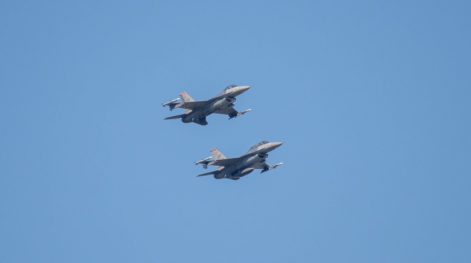 Российские дроны три дня подряд тревожат восточный фланг НАТО Два истребителя F-16 в парном полёте на фоне ясного голубого неба