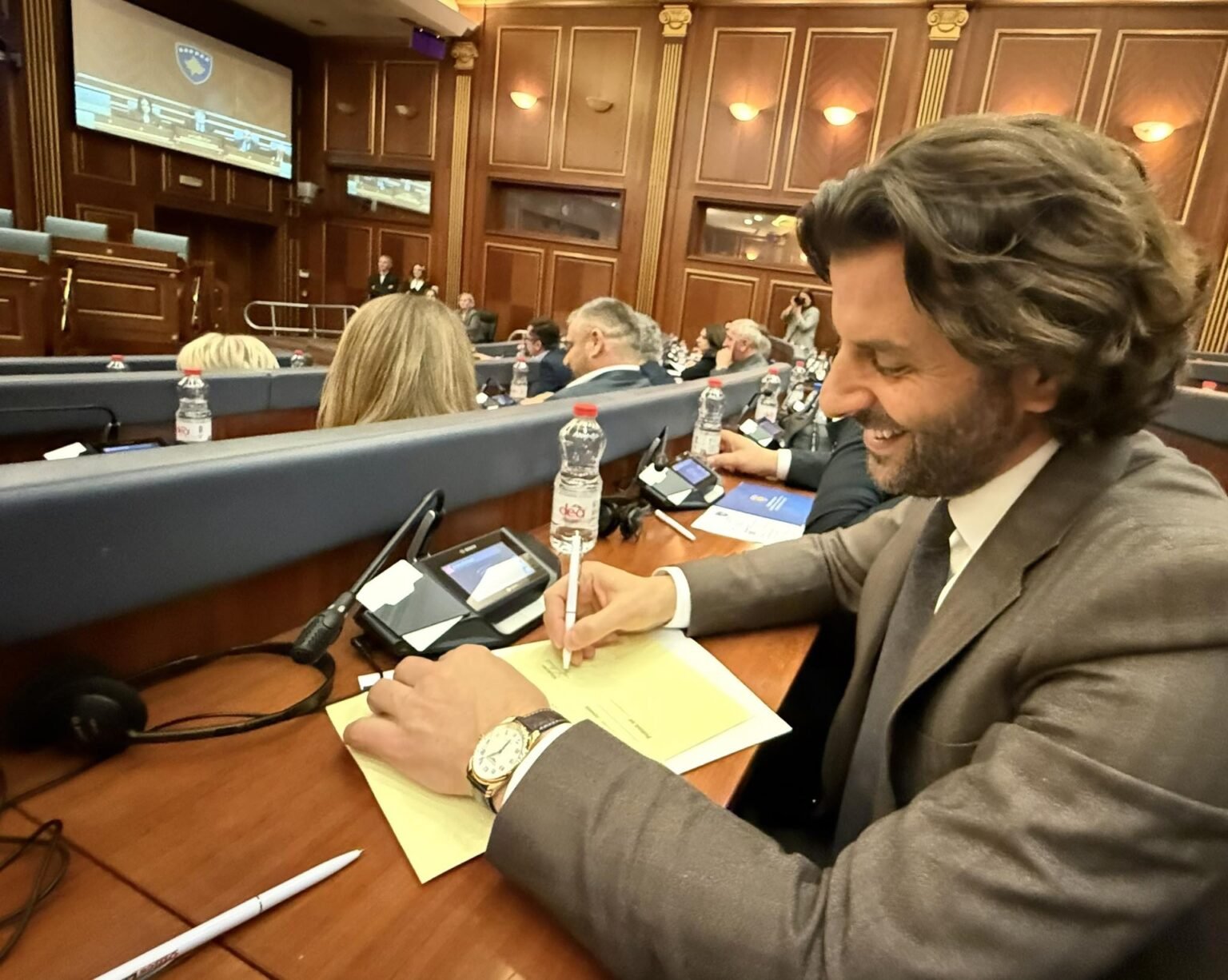Незир Краки в зале парламента Косово, делает записи во время заседания