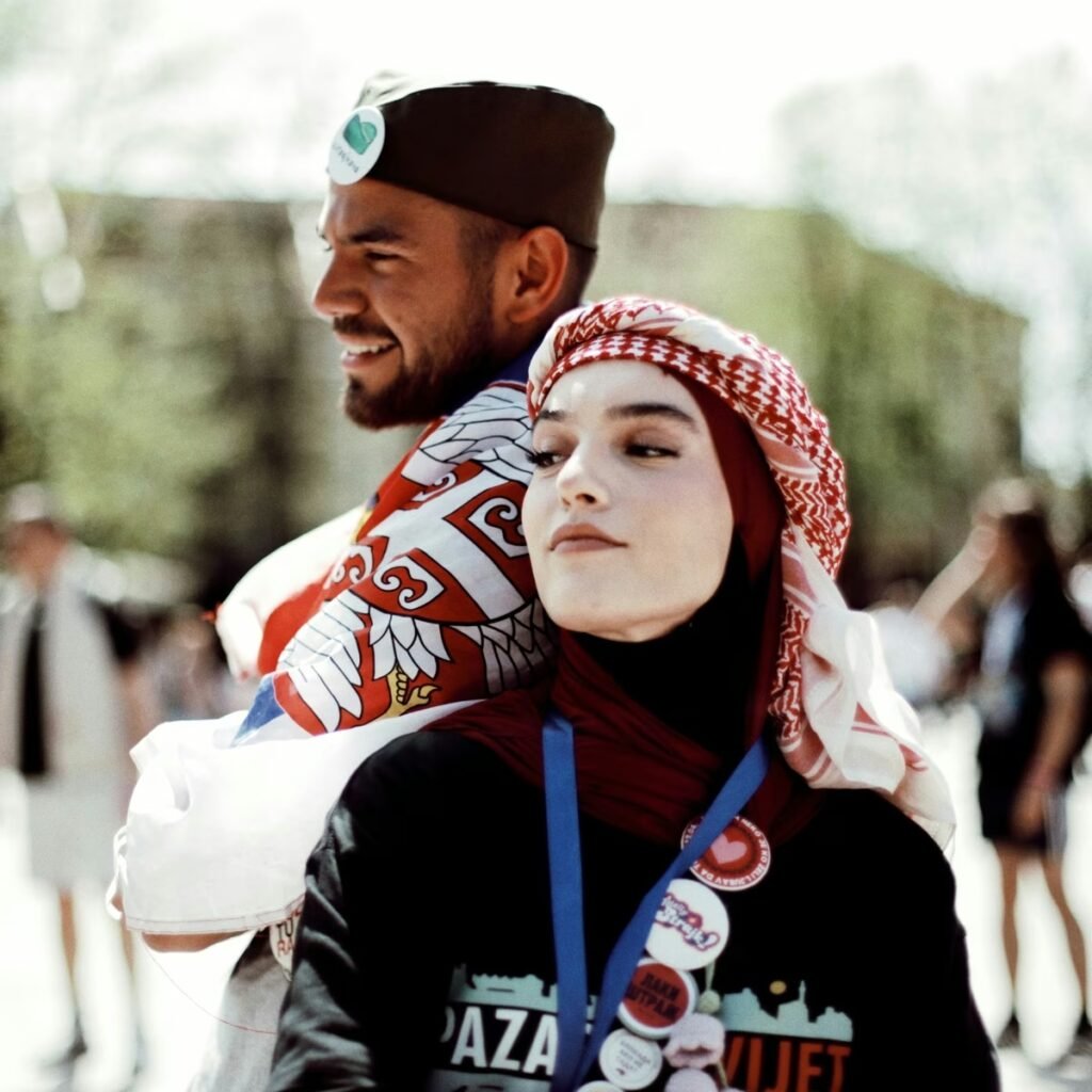 Молодые бошняки на протесте: юноша в шайкаче с сербским флагом и девушка в куфии — образ новой сербской идентичности. Фото: N1 Info