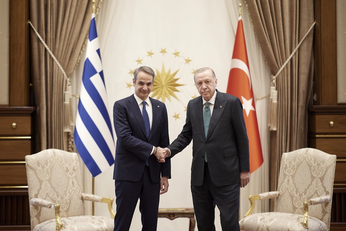 Кириакос Мицотакис и Реджеп Тайип Эрдоган обмениваются рукопожатием на фоне флагов Греции и Турции и президентского герба в Анкаре. Фото: Dimitris Papamitsos