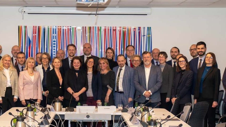 Групповое фото встречи с иностранными послами на фоне разноцветных флагов