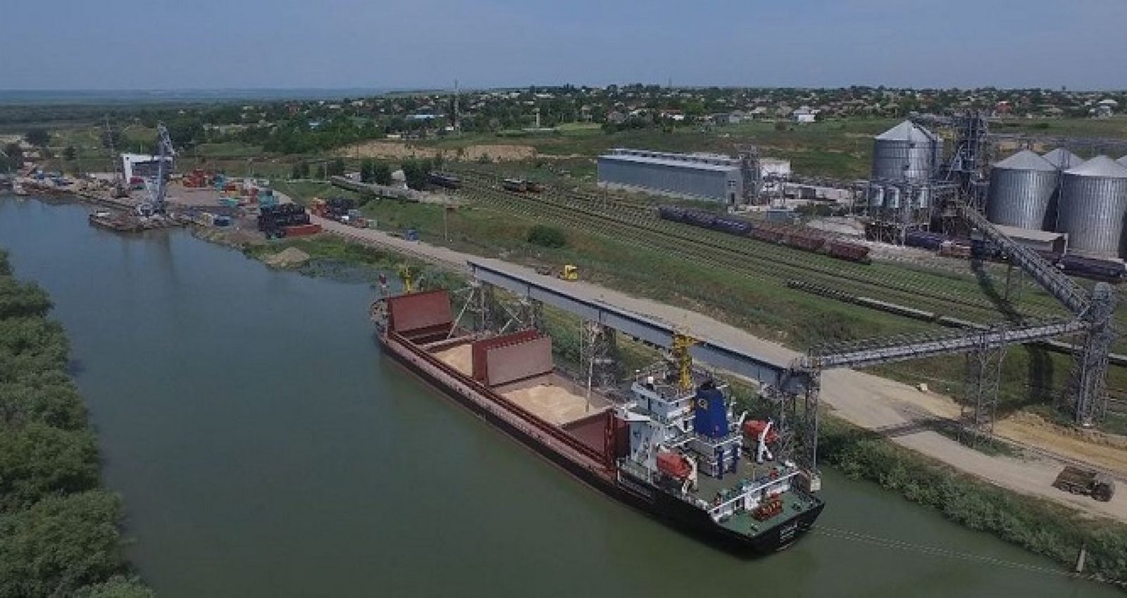 Грузовое судно с открытыми трюмами загружается зерном у причала порта Джурджулешть. Фото: Realitatea.md