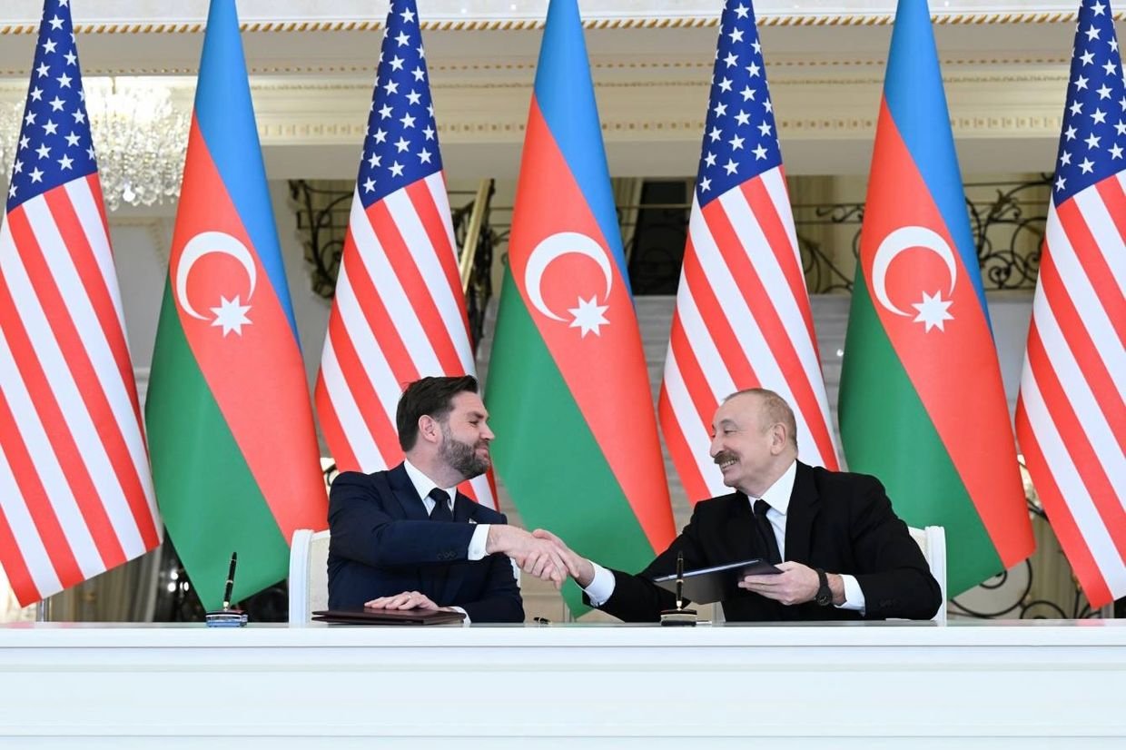 Vance shaking hands with Aliyev in Baku with Azerbaijani and US flags