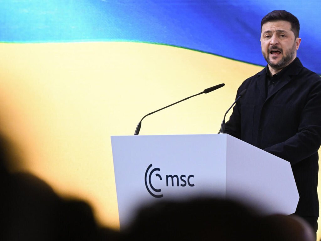 Зеленский публично высмеял Орбана в Мюнхене — тот ответил ультиматумом Владимир Зеленский за трибуной Мюнхенской конференции по безопасности, в зале видны силуэты слушателей. Фото: France 24