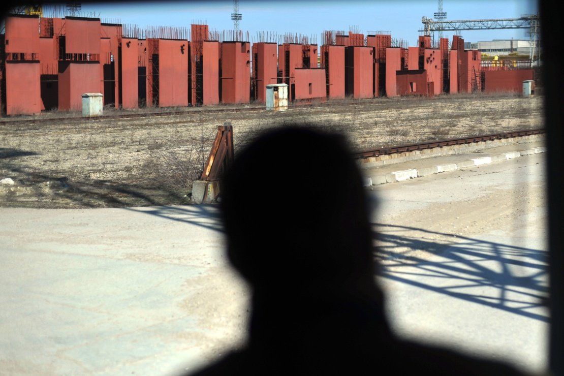 Заброшенная стройплощадка с ржавыми красными конструкциями и арматурой