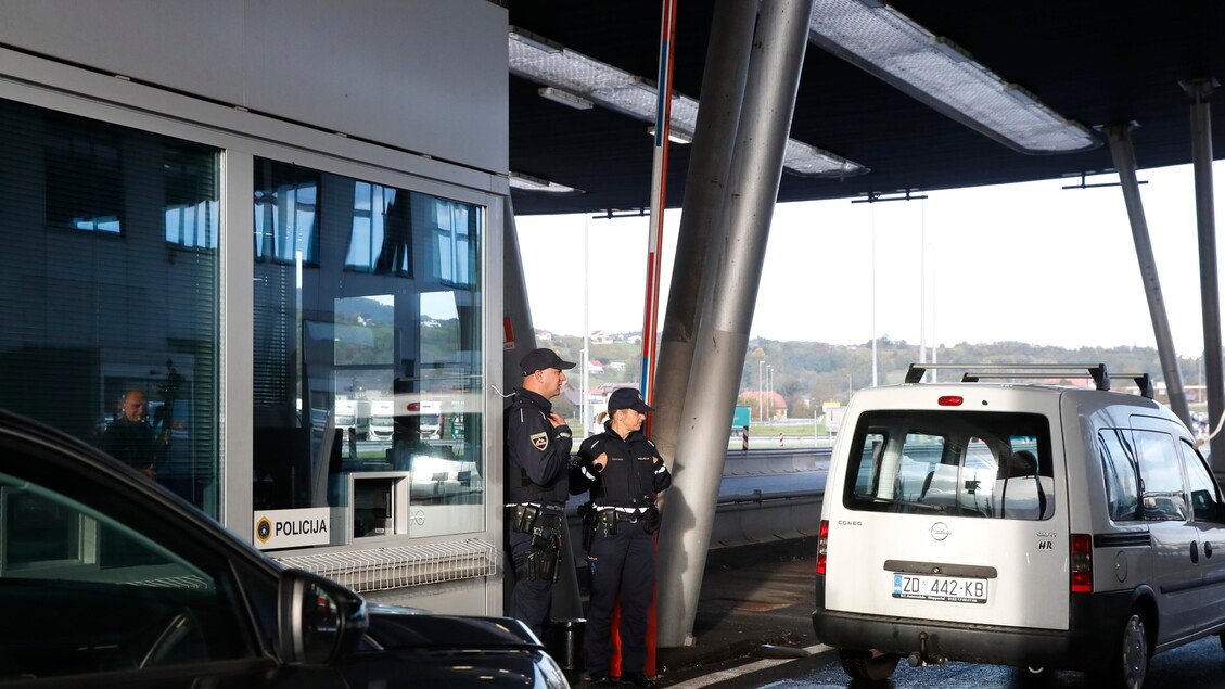 Словенские полицейские на пограничном пункте, видна надпись POLICIJA