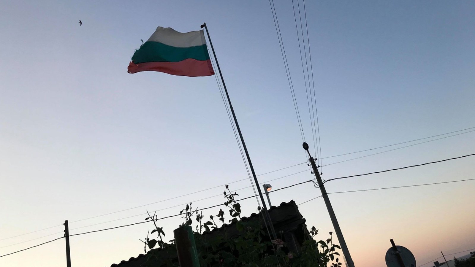 Bulgarian flag flying at sunset in rural village setting, symbolizing Bulgarian community presence in Moldova