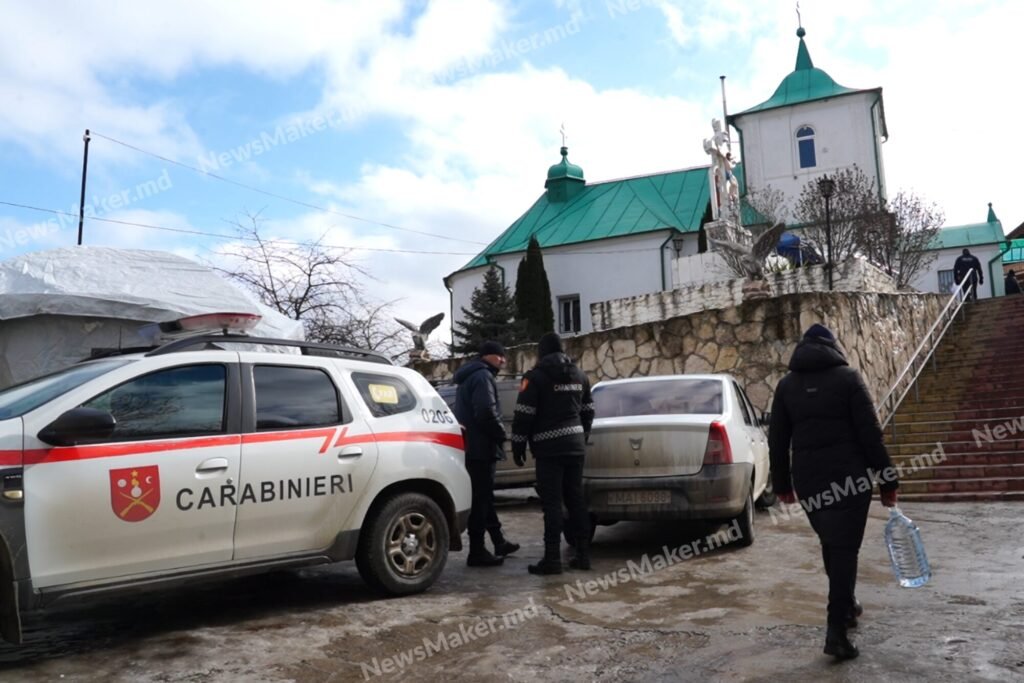 Carabinieri vehicle near village church with officers