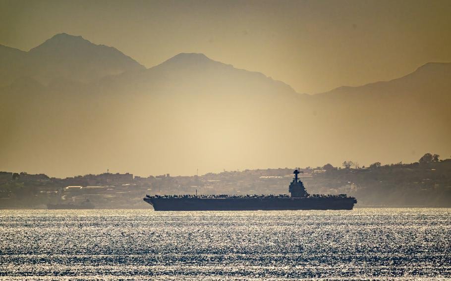 Американский авианосец проходит пролив на фоне гор