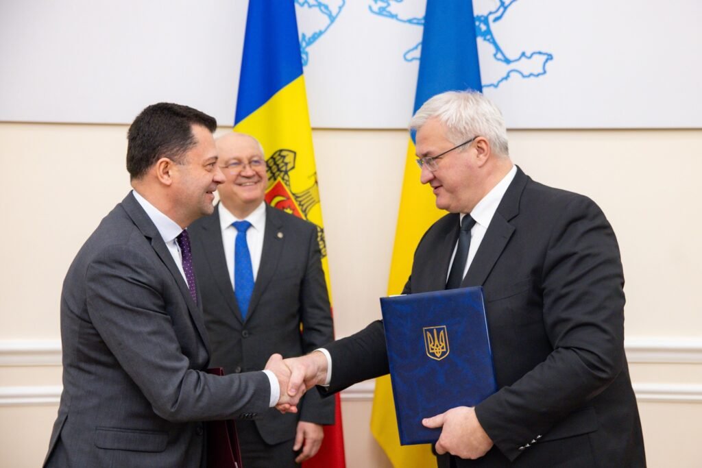 Представители Молдовы и Украины обмениваются рукопожатием после подписания соглашения о пункте пропуска